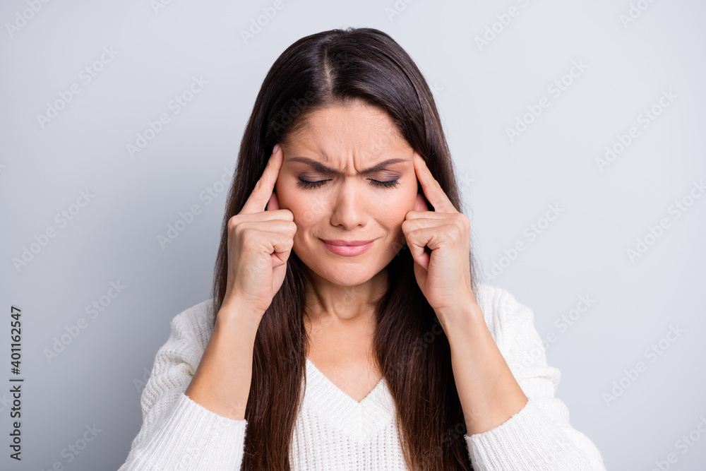 Portrait of mature unhappy sad sick ill woman suffering headache hold fingers on temples isolated on grey color background Portrait of mature unhappy sad sick ill woman suffering headache hold fingers on temples isolated on grey color background