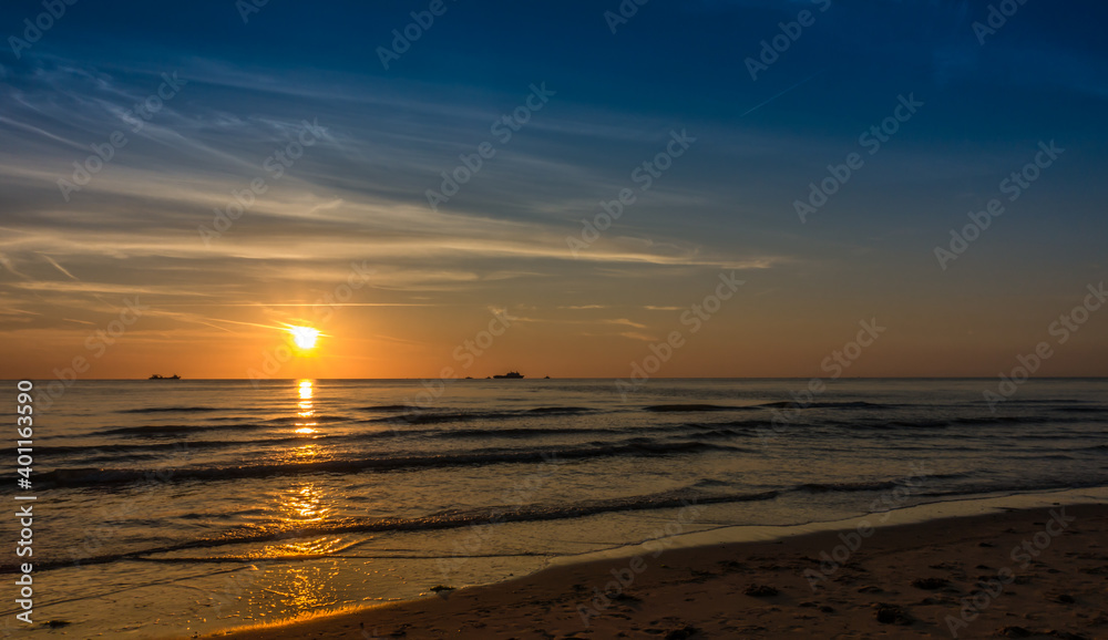 Golden natural sea sunset view of orange sky landscape. Sunset or sunrise reflection in nature with sun in clouds above black sea scenery.