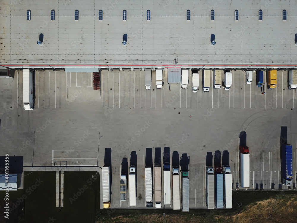 Aerial view of goods warehouse. Logistics center in industrial city zone from above. Aerial view of trucks loading at logistic center Aerial view of goods warehouse. Logistics center in industrial city zone from above. Aerial view of trucks loading at logistic center
