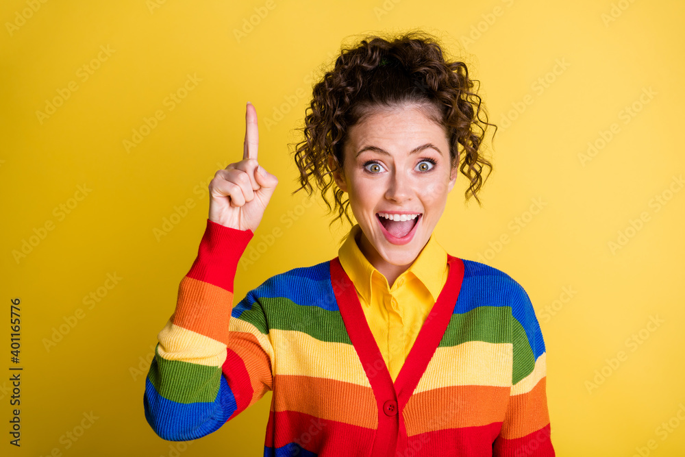 Photo of crazy lady raise index finger up have excellent brilliant idea wear rainbow sweater isolated yellow color background Photo of crazy lady raise index finger up have excellent brilliant idea wear rainbow sweater isolated yellow color background