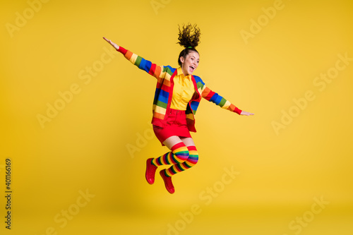 Full size photo of girl jump hold hand look copyspace wear rainbow skirt long socks isolated shine color background