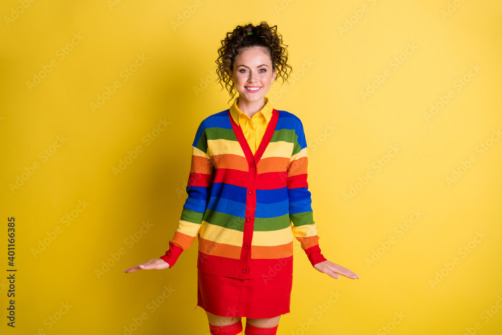 Photo of funky funny girl in vibrant rainbow clothes isolated over yellow color background Photo of funky funny girl in vibrant rainbow clothes isolated over yellow color background