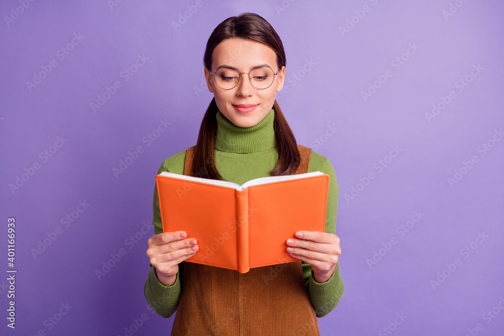 Portrait of attractive focused intellectual girl enjoying reading dictionary isolated over pastel violet color background Portrait of attractive focused intellectual girl enjoying reading dictionary isolated over pastel violet color background