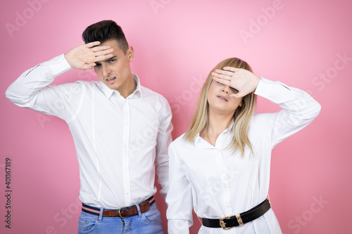 Young couple of girlfriend and boyfriend over isolated pink background Touching forehead for illness and fever, flu and cold, virus sick