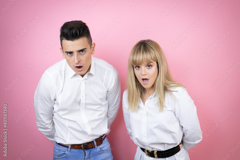 Obraz premium Young couple of girlfriend and boyfriend over isolated pink background afraid and shocked with surprise and amazed expression, fear and excited face.