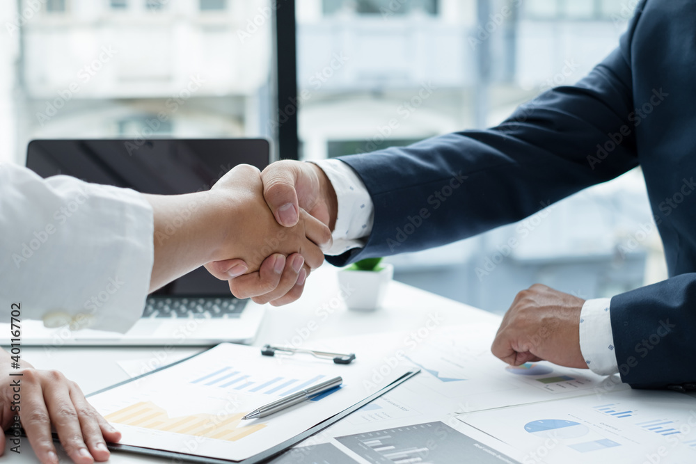 The businessmen shake hands after the meeting was successful and agreed upon The businessmen shake hands after the meeting was successful and agreed upon