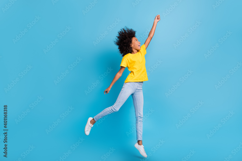 Full size profile side photo of brunette dark skin girl jump catch wear casual outfit isolated on blue color background