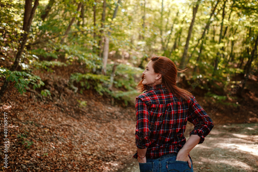 traveler hipster woman standing alone in autumn woods . traveler hipster woman standing alone in autumn woods .