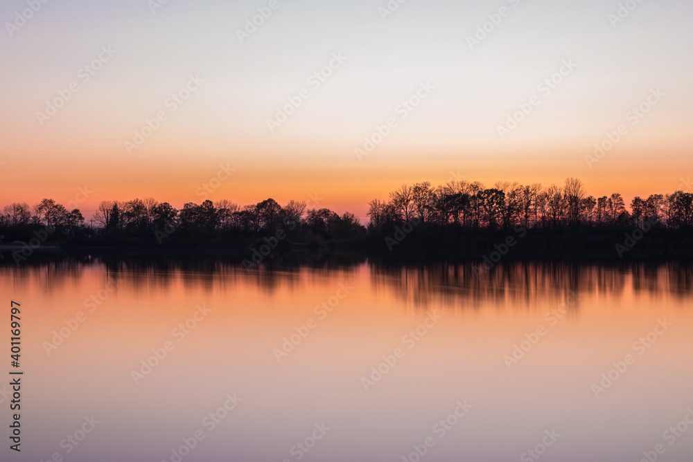 Landschaft und Sonnenuntergang mit Ufer des Sarchinger Weiher mit Spiegelung des Himmels in dem glatten See mit wunderschönen Farben Farbenspiel ohne Wolken, Deutschland