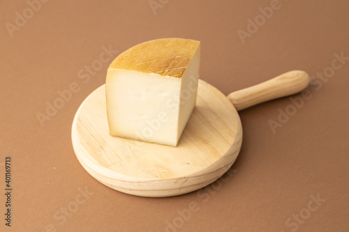 wedge of Spanish cheese on brown background