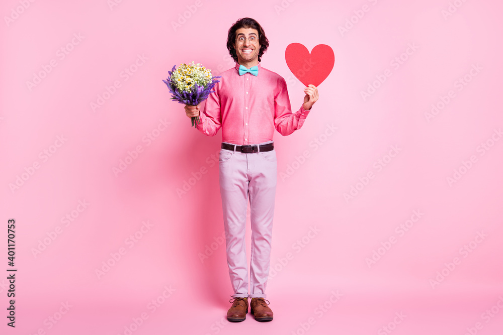 Full length photo of charming man hold red paper heart flowers wear blue bowtie isolated on pink color background