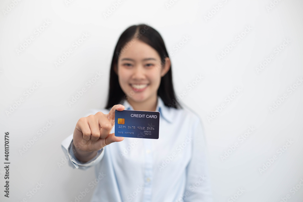 Smiling asian young female model holding up credit card. on white background Smiling asian young female model holding up credit card. on white background