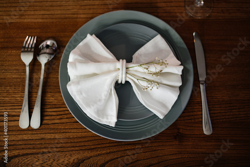 beautiful table setting. napkin in the form of a bow with dried flowers on plate