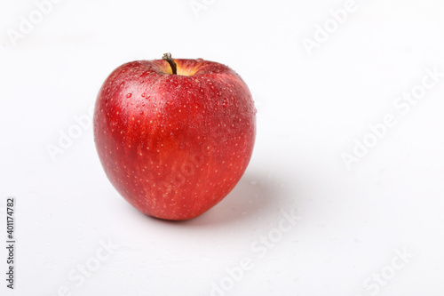 Water drop on fresh red apple on white background