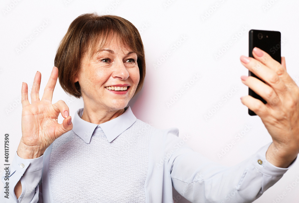 Portrait of her she nice attractive lovely pretty fashionable cheerful cheery grey-haired woman taking making selfie spending free time isolated over white background Portrait of her she nice attractive lovely pretty fashionable cheerful cheery grey-haired woman taking making selfie spending free time isolated over white background