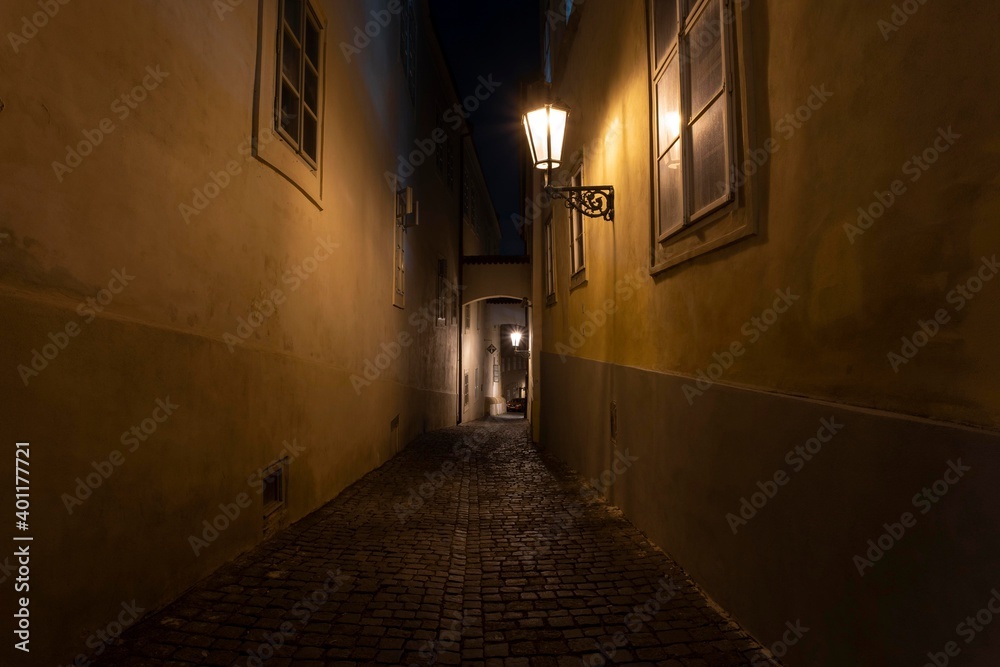 .street lights and pedestrian sidewalk with cobblestones in the center of Prague at night
