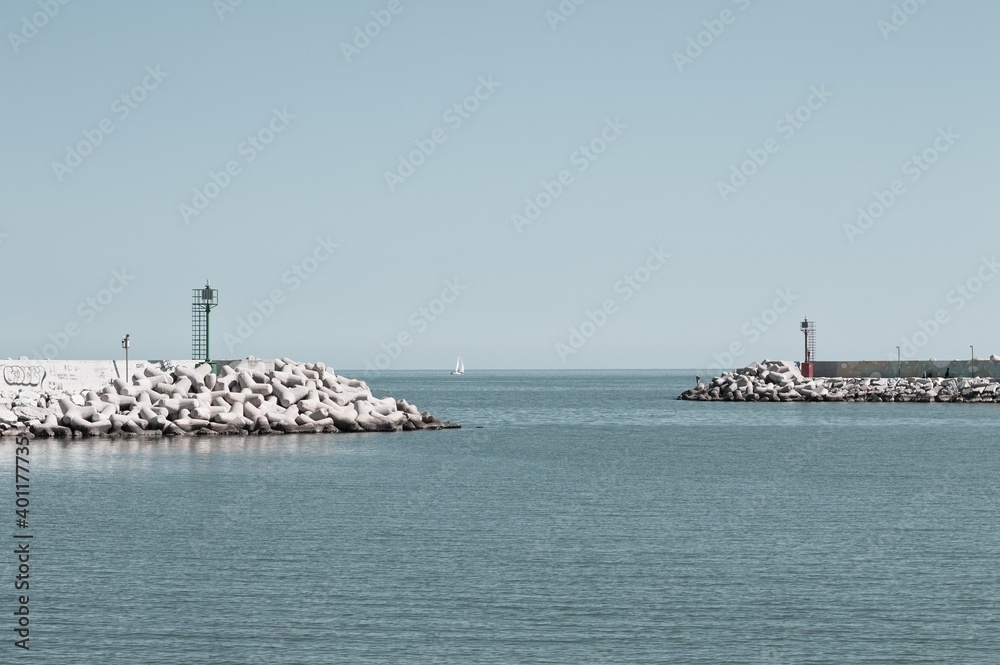 A red and a green lighthouse on the jetty of Pesaro harbour with tetrapod breakwaters (Marche, Italy, Europe)