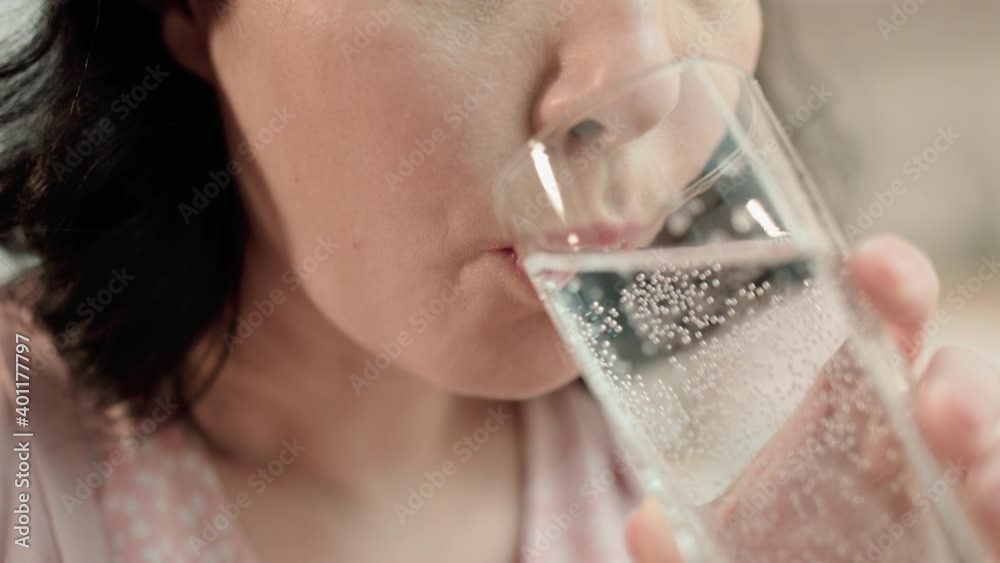 Young female taking pill drinking water from glass, treatment of disease, health Young female taking pill drinking water from glass, treatment of disease, health