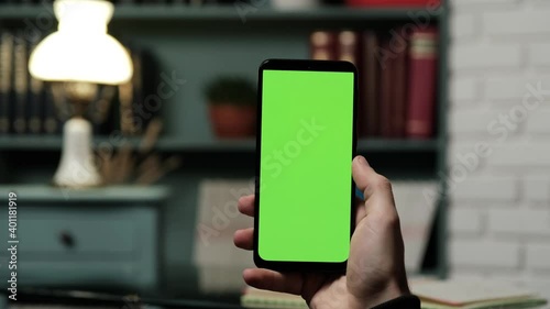 Man Holding Chroma Key Green Screen Smartphone Watching Content Without Touching or Swiping in Home-office. Using Mobile Phone, Browsing Internet, Watching Content.
