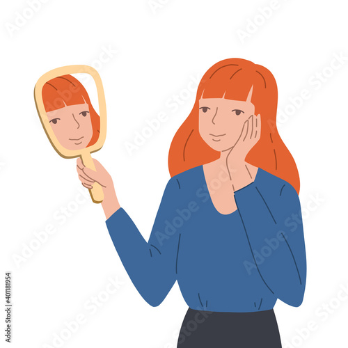 Young woman holding a hand mirror and looking at her own reflection with a joyful expression on her face. Smiling girl holds hand near her face and looks on her mirroring. Concept of self-acceptance