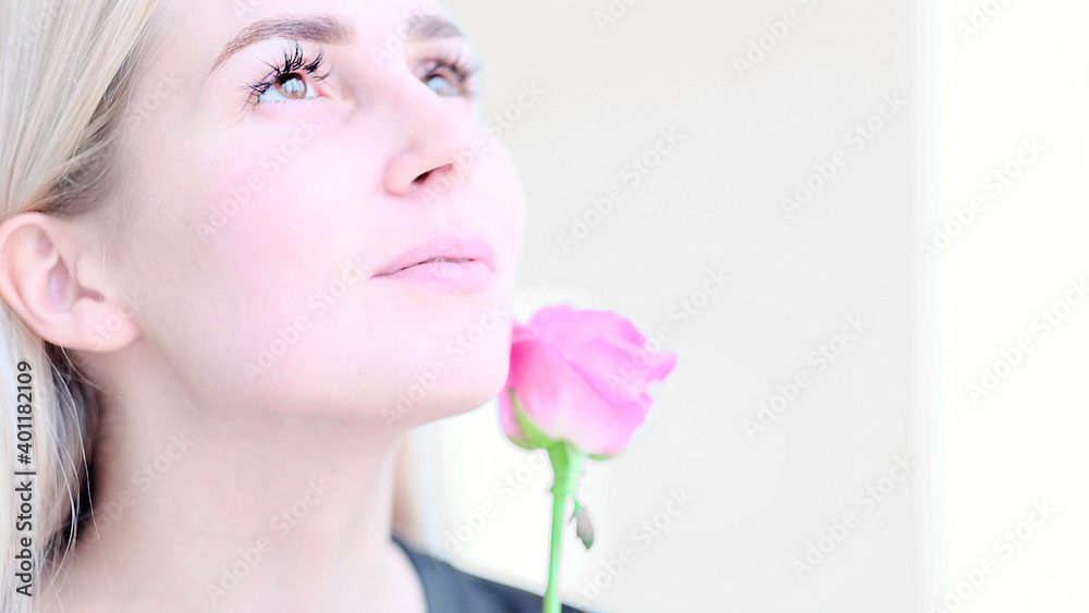 Beautiful young woman with delicate rose flower. Girl clean fresh skin touching her face in flowers. soft focus, selective focus