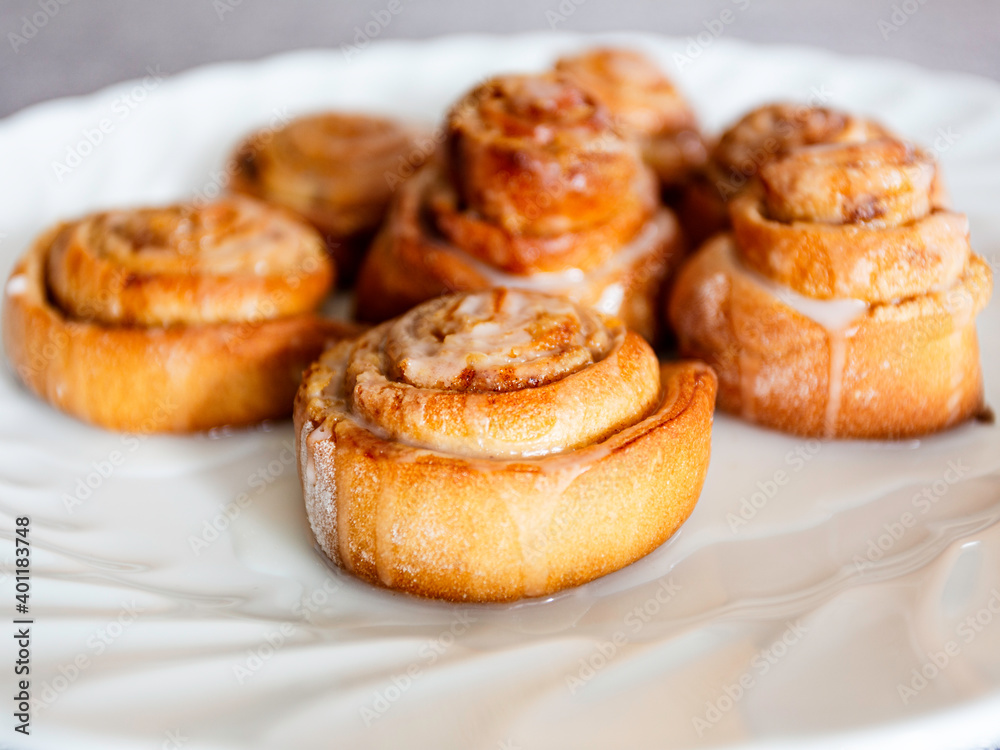 Close up sweet homemade cinnamon rolls on white plate Close up sweet homemade cinnamon rolls on white plate