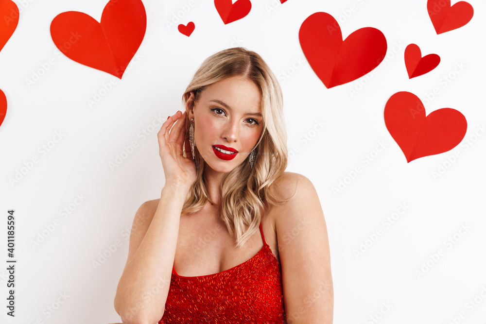 Sensual beautiful girl in red dress posing and looking at camera