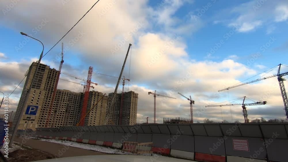 Timelapse work tower cranes when building a large office building against the background of fast running clouds in the blue sky. Timelapse work tower cranes when building a large office building against the background of fast running clouds in the blue sky.