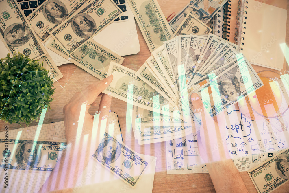Multi exposure of financial graph drawing hologram and USA dollars bills and man hands. Analysis concept. Multi exposure of financial graph drawing hologram and USA dollars bills and man hands. Analysis concept.