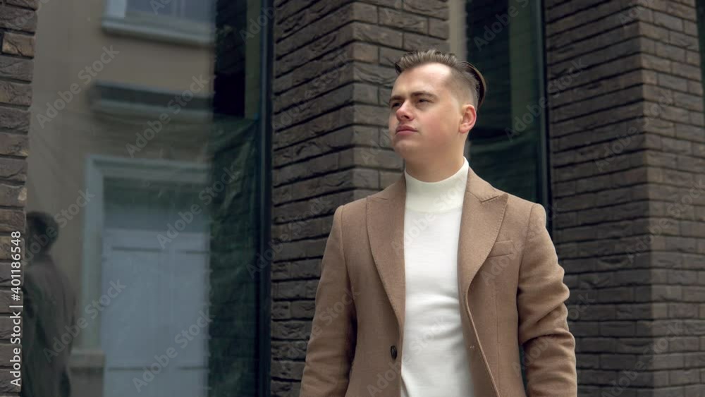 Stylish male businessman in brown coat near office center waiting for business meeting Stylish male businessman in brown coat near office center waiting for business meeting