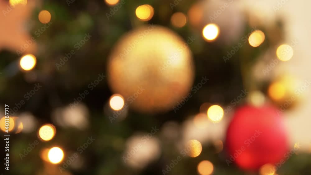 holidays, new year and celebration concept - golden christmas ball decoration with twinkling garland lights on artificial fir tree holidays, new year and celebration concept - golden christmas ball decoration with twinkling garland lights on artificial fir tree