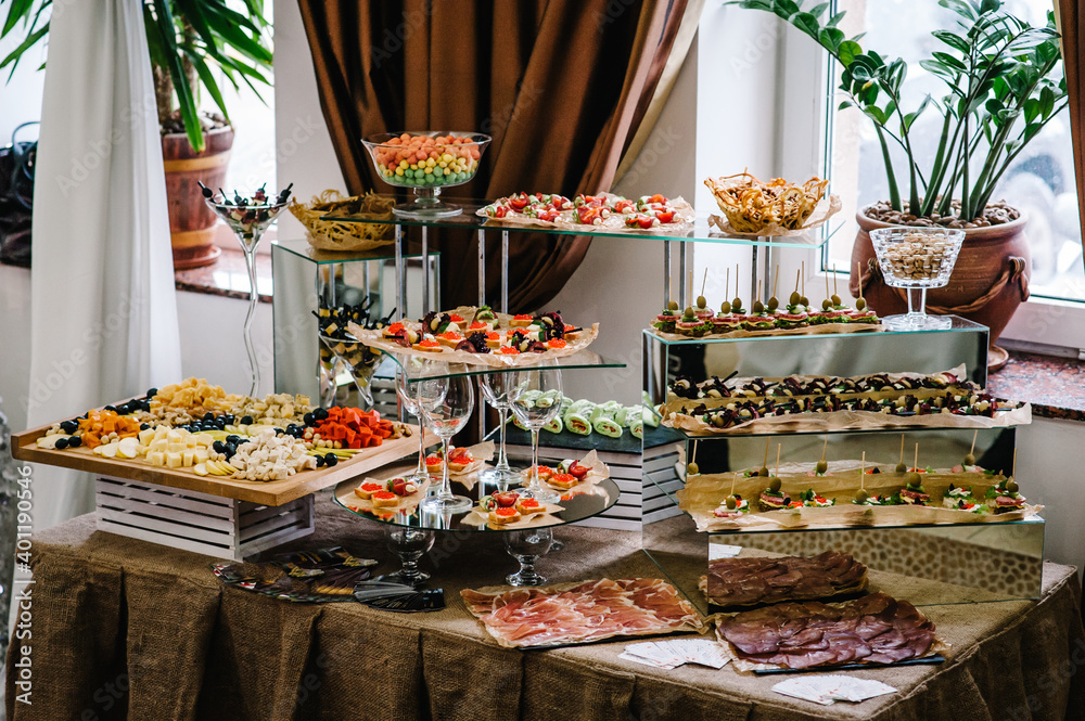 Light snacks in a plate on a buffet table. Assorted mini canapes, delicacies and snacks, restaurant food at event. Seafood. A gala reception. Decorated delicious table for a party goodies.