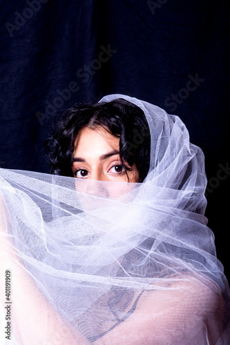 Beautiful woman  with white veil  on black background