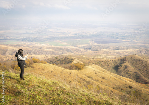 Female person takes a photo from black mountain viewpoint in Vashlovani