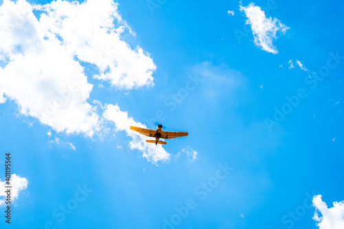 plane with spray on crops in the sky
