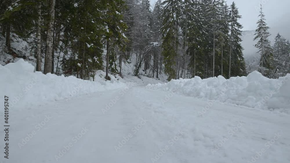 Handheld, low angle view of plowed snowy countryside Alpine road in Slovenia. Beautiful and idyll winter season. Narrow valley in Alps mountains Handheld, low angle view of plowed snowy countryside Alpine road in Slovenia. Beautiful and idyll winter season. Narrow valley in Alps mountains