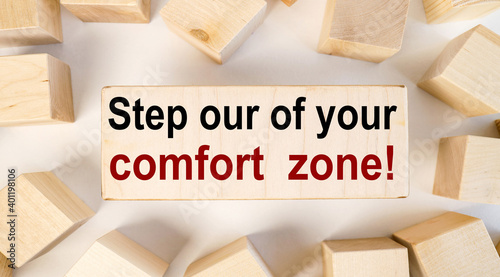 Step Out of Your Comfort Zone. text on wood block on white background