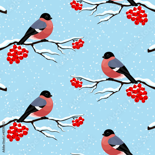 Seamless pattern with bullfinches on rowan branches on a blue background.