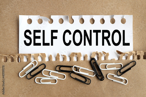 Foto self control, text on white paper on torn paper background