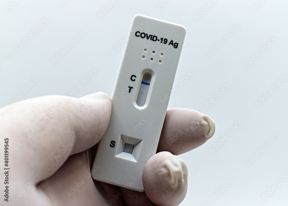 Doctor hand in rubber medical glove holding an antigen rapid test device for Covid-19 test. Doctor hand in rubber medical glove holding an antigen rapid test device for Covid-19 test.