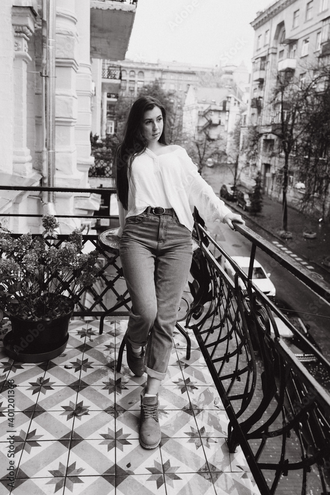 Obraz premium Photoshoot of a beautiful girl in a white shirt on the balcony