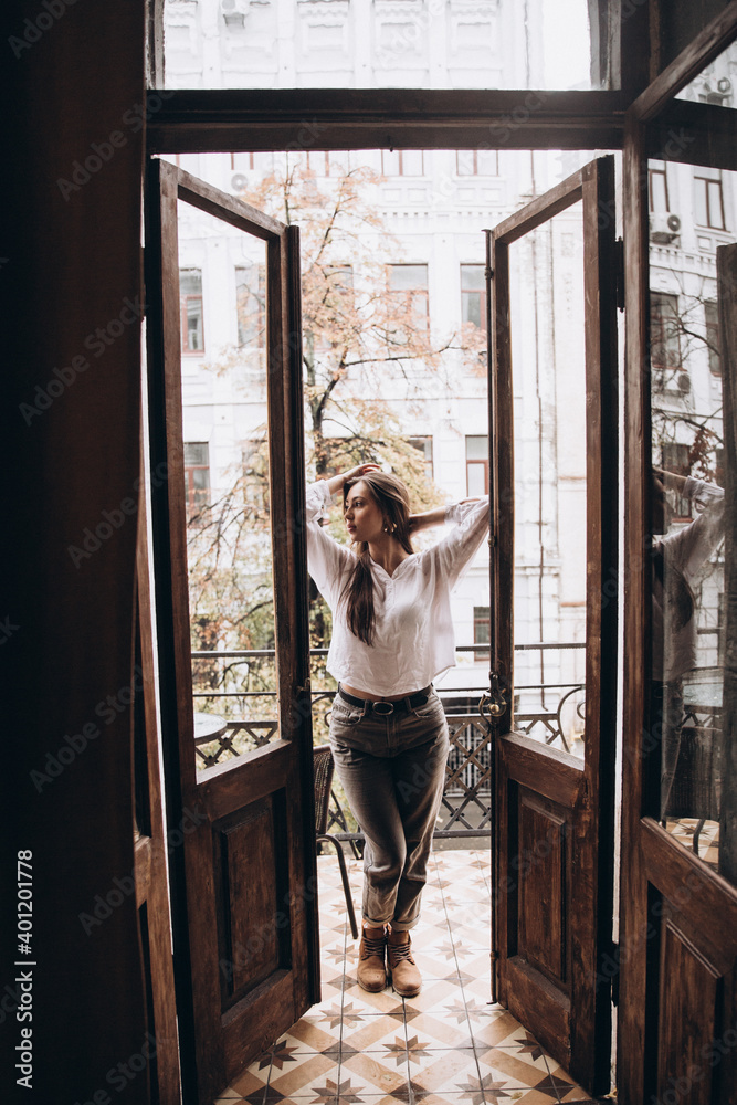 Photoshoot of a beautiful girl in a white shirt on the balcony Photoshoot of a beautiful girl in a white shirt on the balcony
