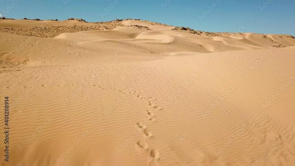 Aerial shot in low attitude of dry desert. Desert landscape with dunes and mountains. Empty golden brown hill background. Aerial shot in low attitude of dry desert. Desert landscape with dunes and mountains. Empty golden brown hill background.