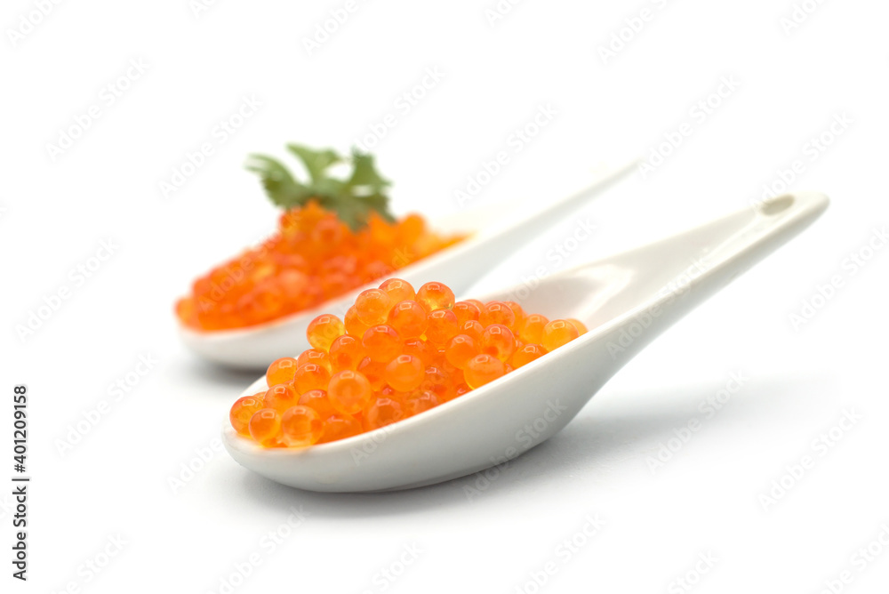 Closeup of trout eggs in a white ceramic spoon on white background Closeup of trout eggs in a white ceramic spoon on white background
