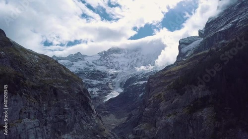 Jungfraujoch mountain in Switzerland. Scenery view of a snowy and cloudy mountain peak with glacier. 