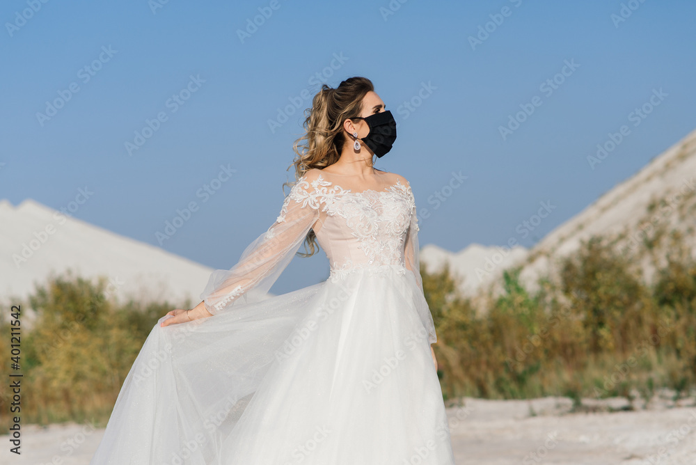 Bride in wedding dress with medical mask at coronavirus covid-19 quarantine period.