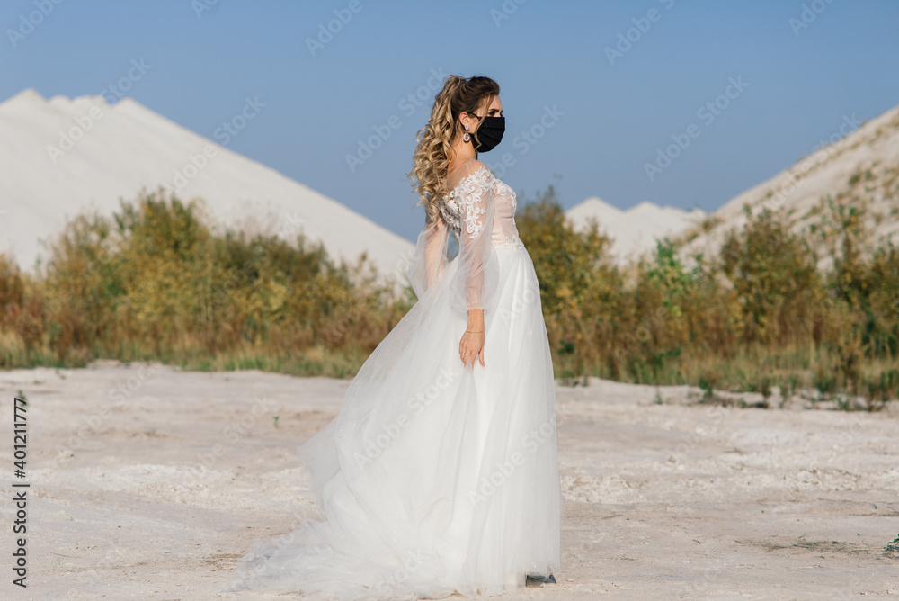 Bride in wedding dress with medical mask at coronavirus covid-19 quarantine period.