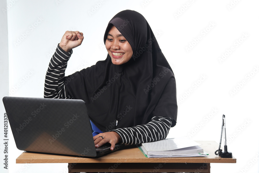 portrait of Asian woman wearing casual clothes working in an office. a veiled woman with a happy expression working at a computer. the concept of a successful and satisfying job portrait of Asian woman wearing casual clothes working in an office. a veiled woman with a happy expression working at a computer. the concept of a successful and satisfying job