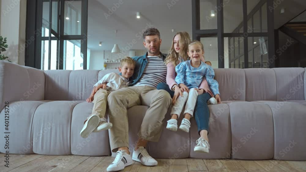 Full length of serious mother pointing with finger while looking at son on couch