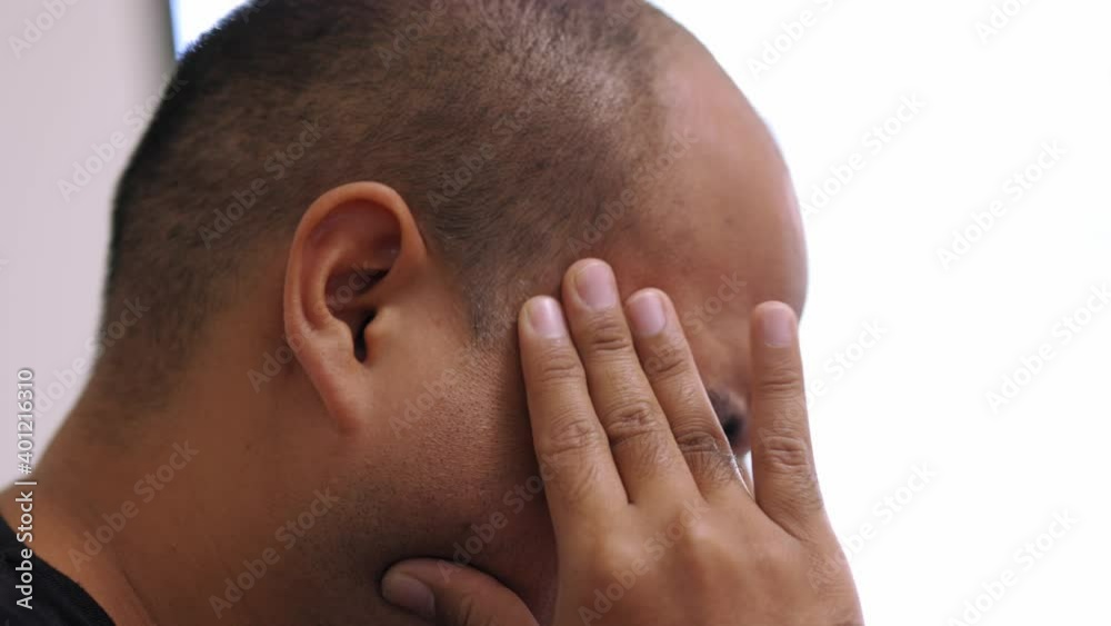 Young asian man hand in head he's feeling depressed, stress, headache be tired from working long time he symptom office syndrome. Young asian man hand in head he's feeling depressed, stress, headache be tired from working long time he symptom office syndrome.